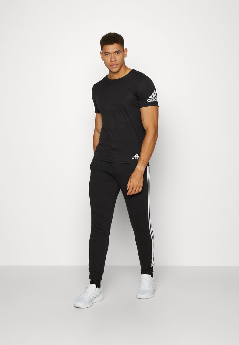 adidas Sportswear adidas Sportswear ESSENTIALS TAPERED CUFF 3 STRIPES PANTS - Tracksuit bottoms - black white Versandkostenfrei